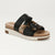 A single women's platform slide sandal with black leather straps, a tortoiseshell-patterned decorative buckle, and a thick cream-colored platform sole, shown on a light gray background.