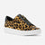 A slip-on platform sneaker featuring a tan and black leopard print pattern, a black leather collar with a gold-tone zipper, and a thick white platform sole.