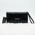 A black patent leather clutch bag with a quilted diamond pattern, featuring a gold-tone 'bebe' logo on the front and a matching black hangtag, displayed on a white faux fur surface.