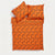 An orange bedding set featuring a duvet cover and two matching pillowcases, all printed with a black Halloween-themed pattern of pumpkins, bats, ghosts, and spiderwebs, shown on a plain white background.