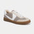 A low-top sneaker in beige, white, and taupe suede with a brown gum sole, shown from a three-quarters angle on a light gray background.