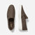 A pair of Michael Kors slip-on sneakers in brown monogram canvas, showing the top-down and side-profile views against a clean white background.