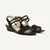 A pair of women's black wedge sandals with criss-cross ankle straps and an open toe, shown on a clean off-white background.