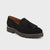 A single black suede tassel loafer with a chunky lug sole, shown from a three-quarters angle on a light gray background.