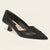A black pointed-toe kitten heel pump with a cap toe and a light beige insole, shown from a three-quarters angle on a light cream background.