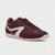 A low-top sneaker in burgundy suede and leather with a contrasting cream-colored chevron side stripe and matching cream midsole, shown from a three-quarters angle on a light gray background.