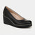 A single black leather wedge pump shoe with a rounded toe and a thick black platform wedge heel, shown from a three-quarters angle on a light gray background.
