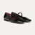 A single black woven Mary Jane flat shoe with a braided strap and pointed toe, shown in profile against a light gray background.