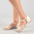 A pair of women's strappy sandals in a light cream or off-white color, shown on a model's feet against a neutral light gray studio background.