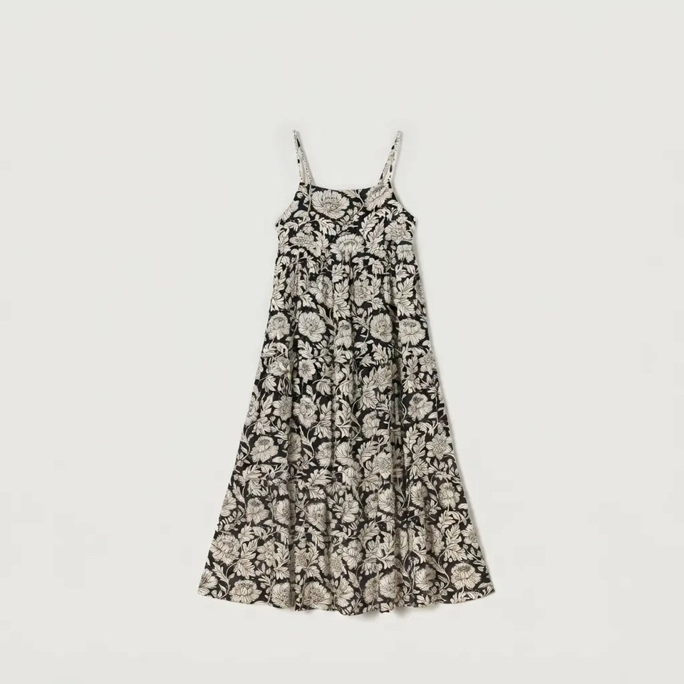 A sleeveless midi dress with thin spaghetti straps and an all-over floral toile pattern in beige and black, shown flat against a light gray background.
