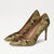 A pair of pointed-toe high heels with a textured, abstract floral pattern in olive green, brown, and beige, set against a plain white background.
