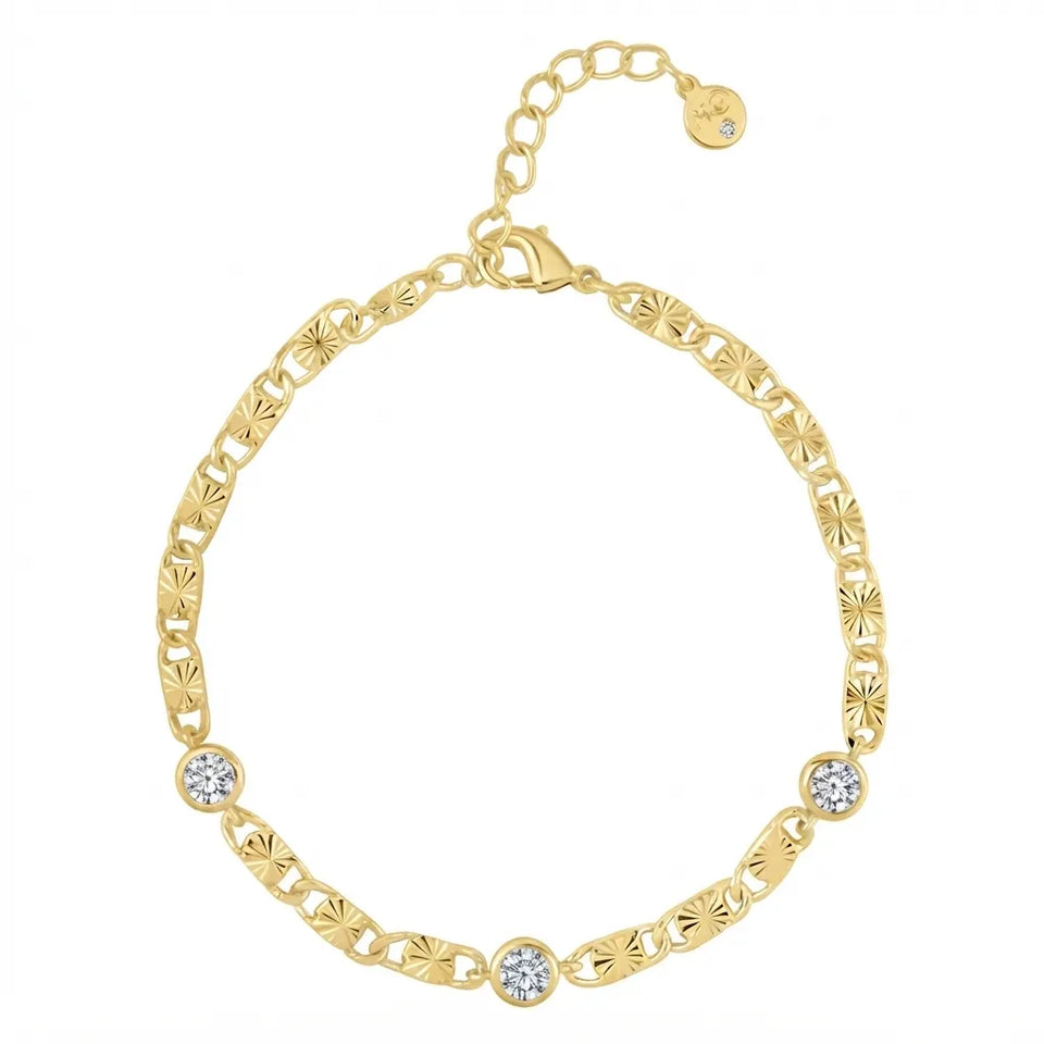 A yellow gold chain bracelet with textured starburst links, featuring three round bezel-set clear crystals on the front, a lobster clasp, and an extender chain with a small round tag.