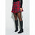 A model wearing a red and navy blue plaid pleated mini skirt with a black long-sleeve top, sheer black tights, and black knee-high boots, standing against a light gray studio background.