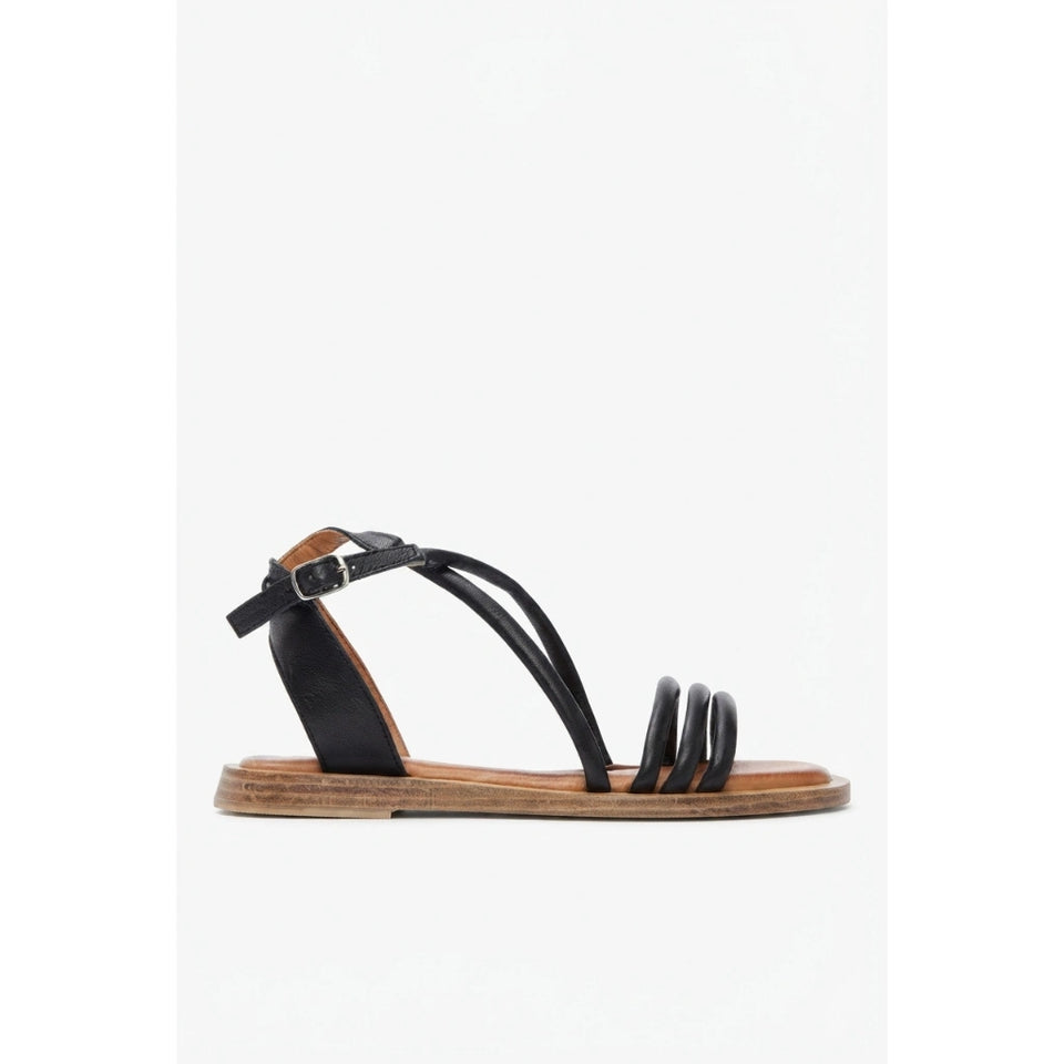 White sandal with a block heel on a light beige background