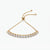 A gold adjustable bracelet featuring a curved row of clear round-cut stones, photographed on a clean white background.