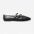 A black leather flat shoe with two decorative straps across the top, each adorned with a gold-tone buckle, shown in profile against a light gray background.