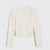 An off-white cable-knit cropped sweater with long sleeves, shown flat against a light gray background.