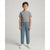 A young boy stands against a light gray studio background wearing a heather gray short-sleeve t-shirt, dusty blue sweatpants, and white sneakers.
