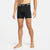 A man wearing black Nike athletic boxer briefs with a white logo and text on the waistband, shown from the waist down against a light gray studio background.