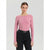 A woman modeling a long-sleeve crewneck top in dusty pink, paired with black jeans and a black belt, against a light gray studio background.