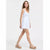 A woman modeling a white sleeveless mini dress with a V-neckline and a matching fabric tie at the waist, paired with white strappy platform sandals, against a plain white studio background.