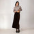 A woman modeling a light gray cowl-neck knit sweater and a dark brown velvet midi skirt, standing against a plain light gray studio background.