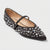 A single black pointed-toe flat shoe decorated with silver rhinestones and a small buckle detail on the strap, shown against a light gray background.