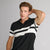 A man wearing a black and white striped short-sleeve polo shirt, posing with one hand behind his head against a solid gray studio background.
