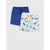 Two pairs of kids' shorts laid flat on a light gray background: one solid royal blue pair and one white pair with a colorful beach-themed print featuring blue trucks, palm trees, and orange accents.