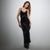 A woman modeling a black velvet slip dress with lace trim on a light gray studio background.