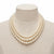 A three-strand pearl necklace displayed on a beige fabric jewelry bust against a white background.