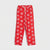 Red lounge pants with an all-over white snowflake pattern and a white drawstring waist, shown flat against a light gray background.