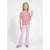 A young girl posing in a pink and white striped short-sleeve t-shirt, light pink flared pants, and matching pink shoes against a plain white studio background.