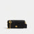 A black leather crossbody phone bag with gold-tone hardware, featuring a prominent interlocking 'C' logo on the chain strap and a circular 'C' emblem on the front flap, set against a plain light gray background.
