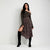 A woman models a dark olive green off-the-shoulder long-sleeve top paired with a dark floral print midi skirt and black over-the-knee boots, standing against a light gray studio background.