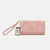 A light pink fabric wristlet clutch with gold-tone hardware, featuring a pleated front flap, a gold 'bebe' logo, and an attached product tag.
