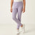A child wearing light lavender ribbed leggings and white sneakers, standing against a clean off-white studio background.