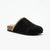A black suede mule slipper with a pointed toe, a decorative zigzag trim of metallic gold and cream along the opening, and a natural cork heel, shown against a plain white background.
