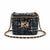 A small tweed shoulder bag in black and blue with a gold-tone chain strap and a prominent interlocking 'C' logo clasp on the front.