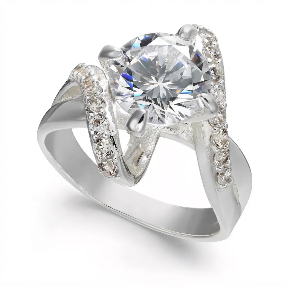 A silver engagement ring featuring a large round brilliant-cut center stone in a prong setting, with curved pavรฉ-set accent stones along the shoulders, shown on a clean white background.