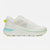 A white athletic sneaker with a textured knit upper, white laces, a thick white cushioned sole, a light blue accent stripe on the midsole, and neon yellow-green accents on the heel pull tab and outsole.