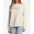 A woman wearing a cream-colored sweatshirt with a pink graphic text print on the chest, paired with light blue jeans, against a plain white background.