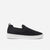 A black slip-on knit sneaker with a white sole, shown in profile against a light gray background. The brand name 'MICHAEL KORS' is debossed on the side of the white sole.
