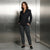 A woman stands in a metallic elevator lobby wearing a black wrap-style blazer with a tie waist and dark gray tailored trousers, paired with black loafers.