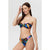 A woman modeling a colorful tropical print bikini against a light gray studio background. The bikini features a strapless bandeau top with a front knot detail and matching high-cut bottoms in a vibrant multicolor pattern of blue, green, orange, pink, and yellow leaves.