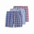 Three pairs of men's boxer briefs arranged in a fan layout on a white background. The front pair is blue plaid with red and green lines, the middle pair is light blue and white striped, and the back pair is red and white plaid.