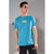 A man wearing a bright turquoise blue crewneck t-shirt with yellow text on the chest that reads 'like a good, nice guy boy'.