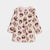 A pink long-sleeve baby dress featuring an all-over Minnie Mouse face print, displayed flat against a light gray background.