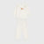 A two-piece baby pajama set in warm off-white fleece, featuring a long-sleeve top with a cute bear face applique on the chest and matching long pants, displayed on a light gray background.