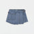 A light blue denim mini skirt with a unique asymmetrical front design, featuring a large front pocket, decorative stitching, and a buttoned waistband, shown against a plain white background.